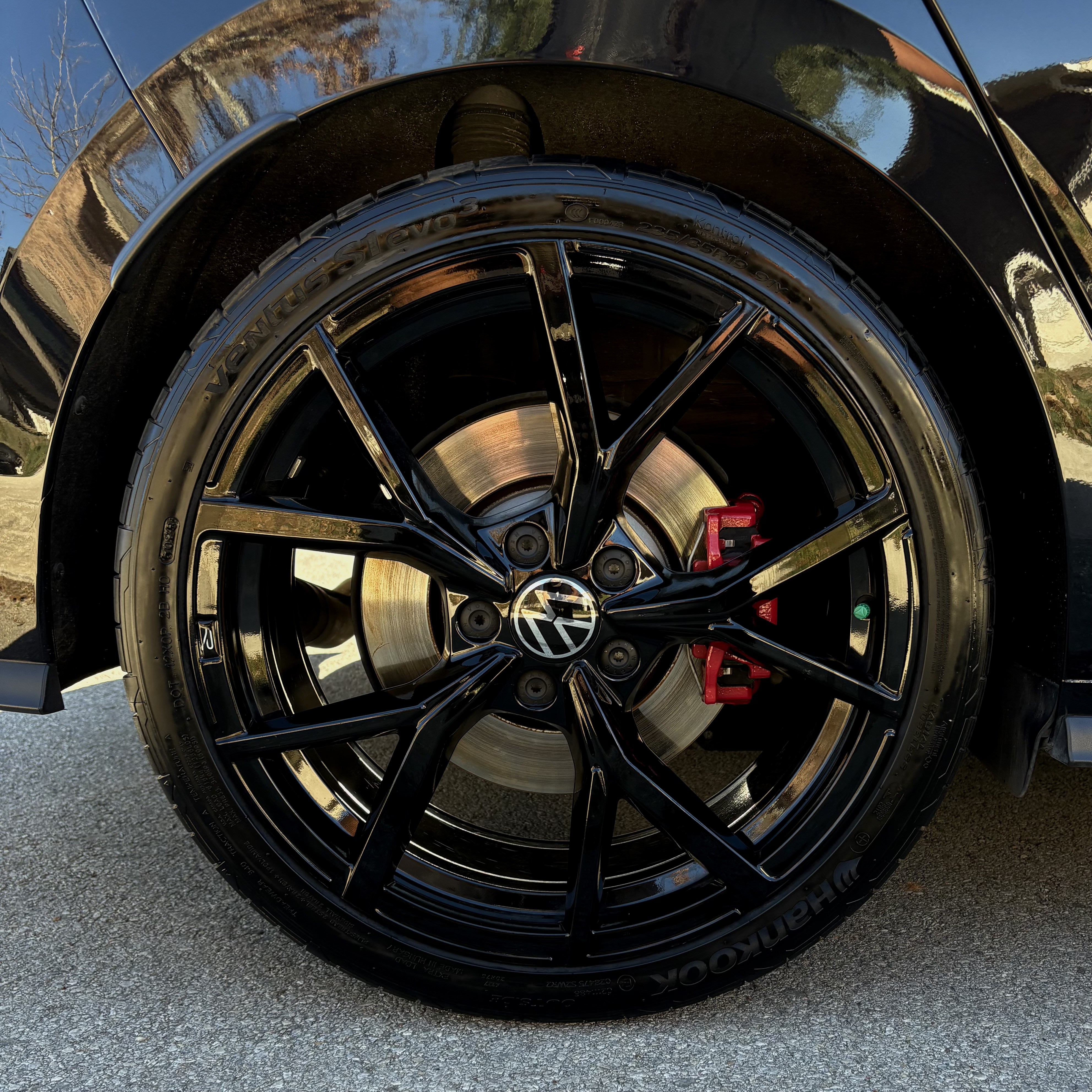 Detailed black alloy wheel with red brake calipers